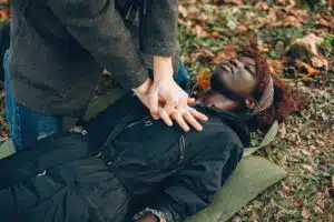 guy help woman african girl is lying unconscious providing first aid park